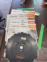 Photo showing two new STIHL 225 mm (8.9 inch) circular saw blades and multiple used 200 mm (7.9 inch) blades still in packaging, indicating condition and sizes matching seller description.
