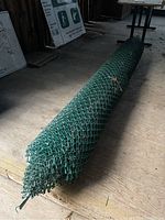 Full view of rolled green vinyl coated chain link fencing, showing length and height dimensions