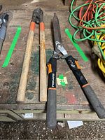 Photo of two Fiskars gardening shears and one pair of lopper clippers with wooden handles showing overall condition and wear