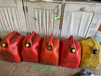 Four red 20L gas cans and two yellow fuel cans lined up on floor showing wear and dirt marks