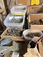Assorted nails in plastic containers and cardboard boxes with metal brackets in foreground
