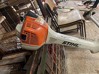 Side view of STIHL brush trimmer engine housing and bicycle handlebar