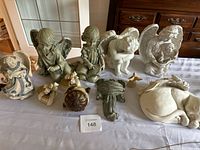 Top view of multiple angel and cherub figurines clustered together including musical box and other decorative items.