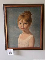 Framed portrait print of young girl with red hair, white dress, against blue-gray background.