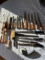 Full layout of all kitchen cutting tools on white cloth background