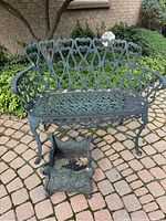 Front view of cast aluminum bench and planter pot on stone patio