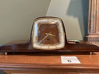 Front view of the Franz Hermle Forestville mantel clock showing its wooden case and square dial with gold accents.