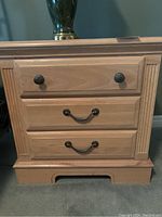 Front view of one Broyhill nightstand showing wood finish, drawer handles and surface condition.