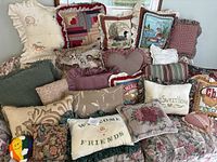 Full view of large assortment of assorted accent pillows piled together on a couch, showcasing various patterns, colors, and textures.