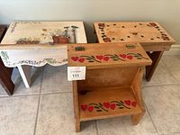Photo showing the three hand-painted wooden step stools with visible different decorative themes and general wood condition.