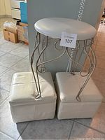 Vanity stool with two storage ottomans grouped together. Shows overall lot contents and condition.