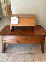 Pair of wooden step stools stacked, showing different sizes and finishes