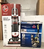 Photo showing the original boxes of two vacuum cleaners: Hoover PowerDrive Swivel XL and Bissell PowerClean TurboBrush Pet.