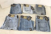 Six pairs of folded 5ive Jungle & Co. denim jeans showing back pockets and branding tags.