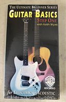 Sealed VHS tape titled 'The Ultimate Beginner Series Guitar Basics Step One with Keith Wyatt' featuring images of electric and acoustic guitars on cover.