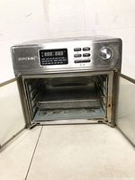 Front view of the Kalorik Maxx Air Fryer Oven showing digital control panel and open double glass doors.