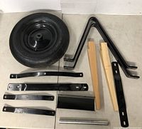 Photos of Toolway wheelbarrow assembly kit components: tire, metal frames, wooden handles, hardware, and manual.