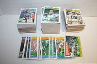 Stacks of 1987 Topps NFL football cards including various team and player cards and record breakers, visibly in good condition with no major creases or damage.