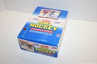 Closed blue and white 1990 Score NHL Hockey Premier Edition box showing front and top sides with colorful graphics and text.