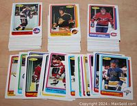 Stacks of hockey cards from the 1986/87 OPC NHL series showing various players with colorful borders