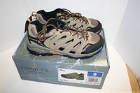 Pair of Cloudveil Expedition hiking shoes new and unused placed on a Cloudveil branded shoebox marked size 9 with green, brown and black colors.