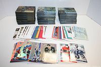 Large stacks of hockey trading cards including acetate and regular cards with visible player images and holographic elements