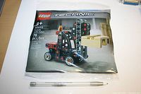 Front view of sealed LEGO Technic Forklift with Pallet set 30655 pouch bag with 78 pieces, pen for scale