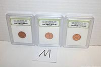 Three 1959-D US Memorial cents encapsulated in slab holders and labeled as First Year Brilliant Uncirculated by International Numismatic Bureau, displayed side by side.