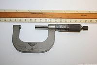 Side view of the Swedish Gauge Co. micrometer showing the handle, frame, thimble, and scale against a ruler for size reference.
