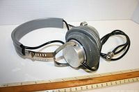 Full view of the vintage war era headphones showing metal frame, padded ear cups, and cable.