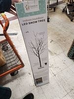 Box showing brand, specifications, and usage information for the 4ft LED Snow Tree decoration.