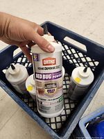 Six bottles of Ortho Home Defense Bed Bug Powder in a blue plastic crate, visible labels and nozzles for application.