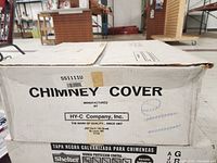 Closed cardboard box labeled 'Chimney Cover' by HY-C Company, Inc. Model SS1111U, shows some wear on corners.
