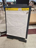 Front view of collapsible easel board holding a large white Post-it paper pad with yellow Post-it branding at the top