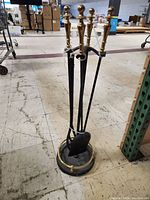 Side view of the fireplace tool kit showing all tools and stand