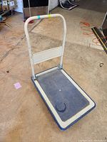 Full view of mini flatbed cart showing upright handle and platform.