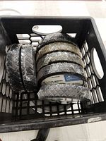 Tote of wrapped wheels showing mostly steel frame wheels inside a black tote.