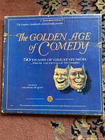 Photo of The Golden Age of Comedy record jacket in blue with comedy and tragedy masks and gold text.
