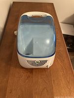 Top view of Vicks humidifier showing translucent blue water tank and white base with vent grille