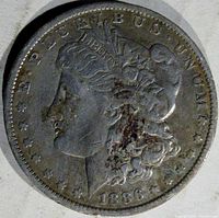 Obverse side of the 1886-O Morgan silver dollar coin showing Liberty's profile and date 1886.