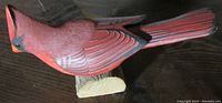Side profile of the cardinal figure mounted on a natural wood base, highlighting the body shape and painted details.