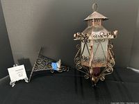 Full shot of the Spanish Revival Gothic metal lantern light fixture with scrollwork and wall bracket.