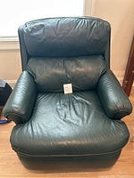 Front-facing photo of hunter green leather recliner chair highlighting padded backrest, arms, and seat cushion.