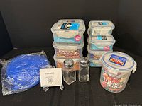 Full lot overview showing stacked Lock&Lock containers, salt and pepper shakers, and packaged blue silicone bowl toppers.