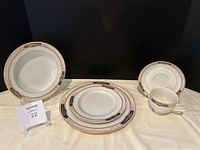 Wide view showing one dinner plate, salad plate, soup bowl, coffee cup with saucer