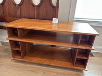 Front and side views of solid wood entertainment center showing open compartments and medium brown finish.