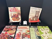 Shows six vintage magazines on display including Woman's Day 1945 and Holiday Homecoming with a turkey dinner on cover, plus craft and home related magazines.