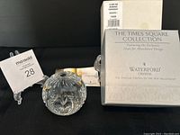 Photo of Waterford Crystal paperweight with intricate cut design sitting next to original product box and auction tag.