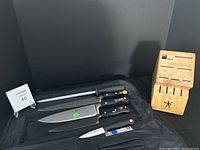 Overview of all knives, honing steel, block and case arranged on knife roll