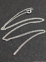 Full view of the gold chain on black background showing chain design and length.